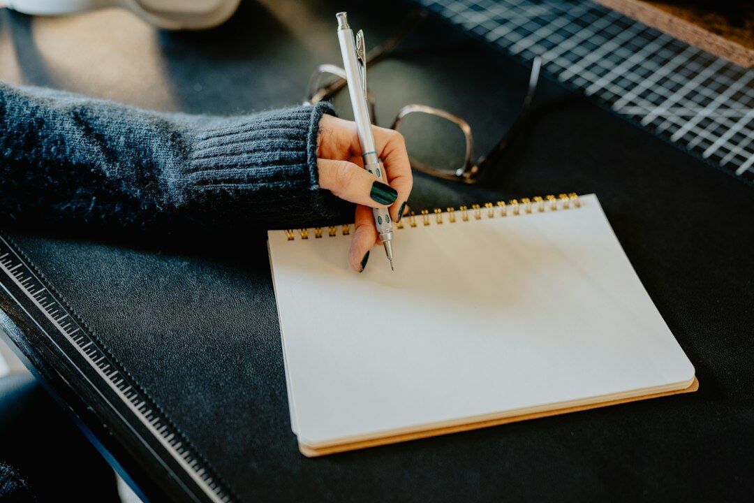 person writing notes in notebook